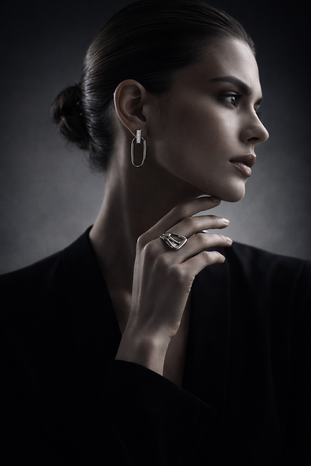 Model wearing polished silver jewelry in an editorial luxury campaign.